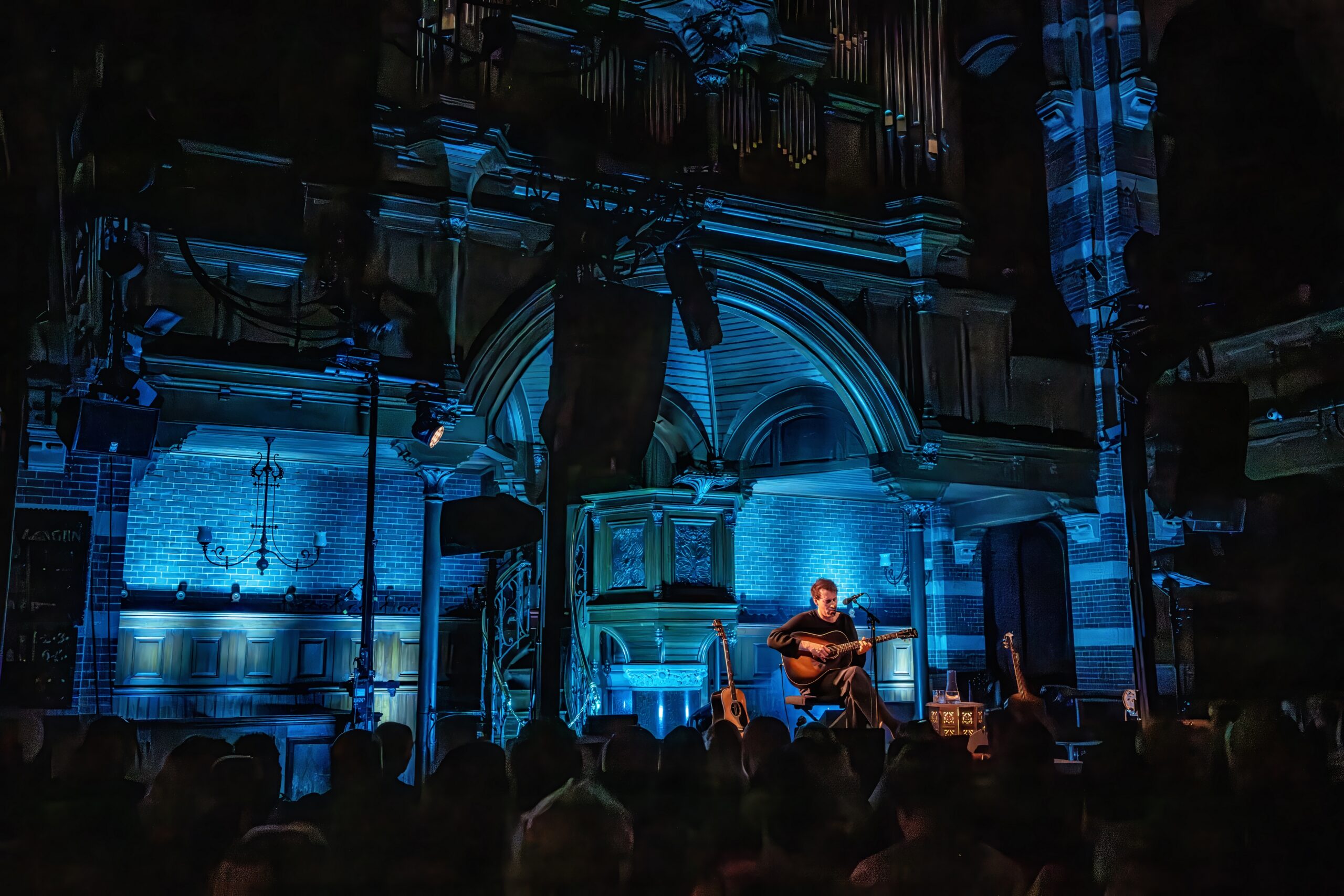 Wijds zicht op het kerkinterieur van Arminius met blauw verlicht orgel tijdens het concert