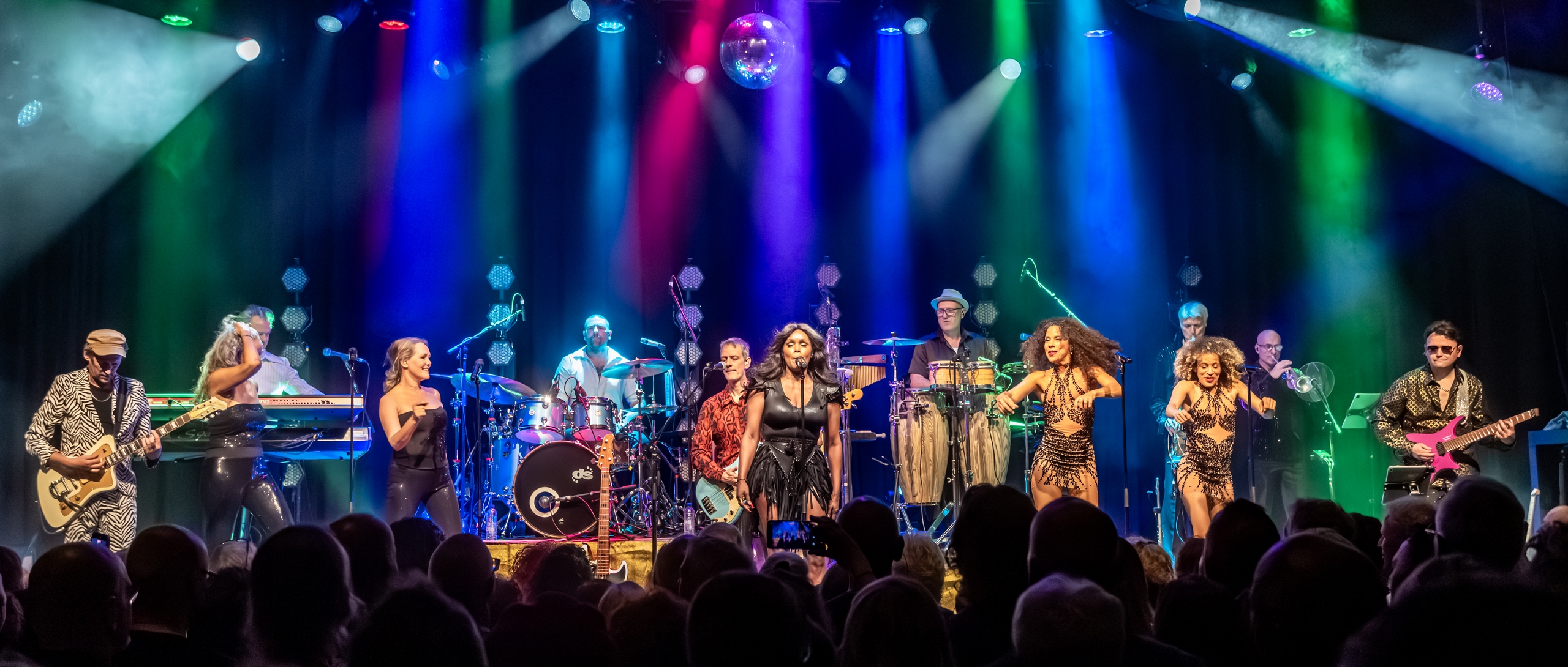 Wijds podiumbeeld van Donna's Hot Stuff in Poppodium Boerderij met publiek op de voorgrond